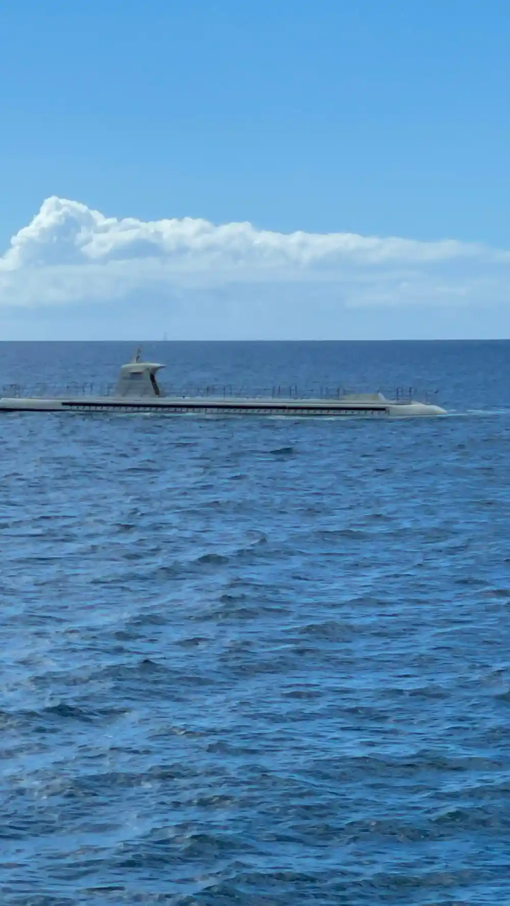 The submarine running on the surface with the deck rail along its length
