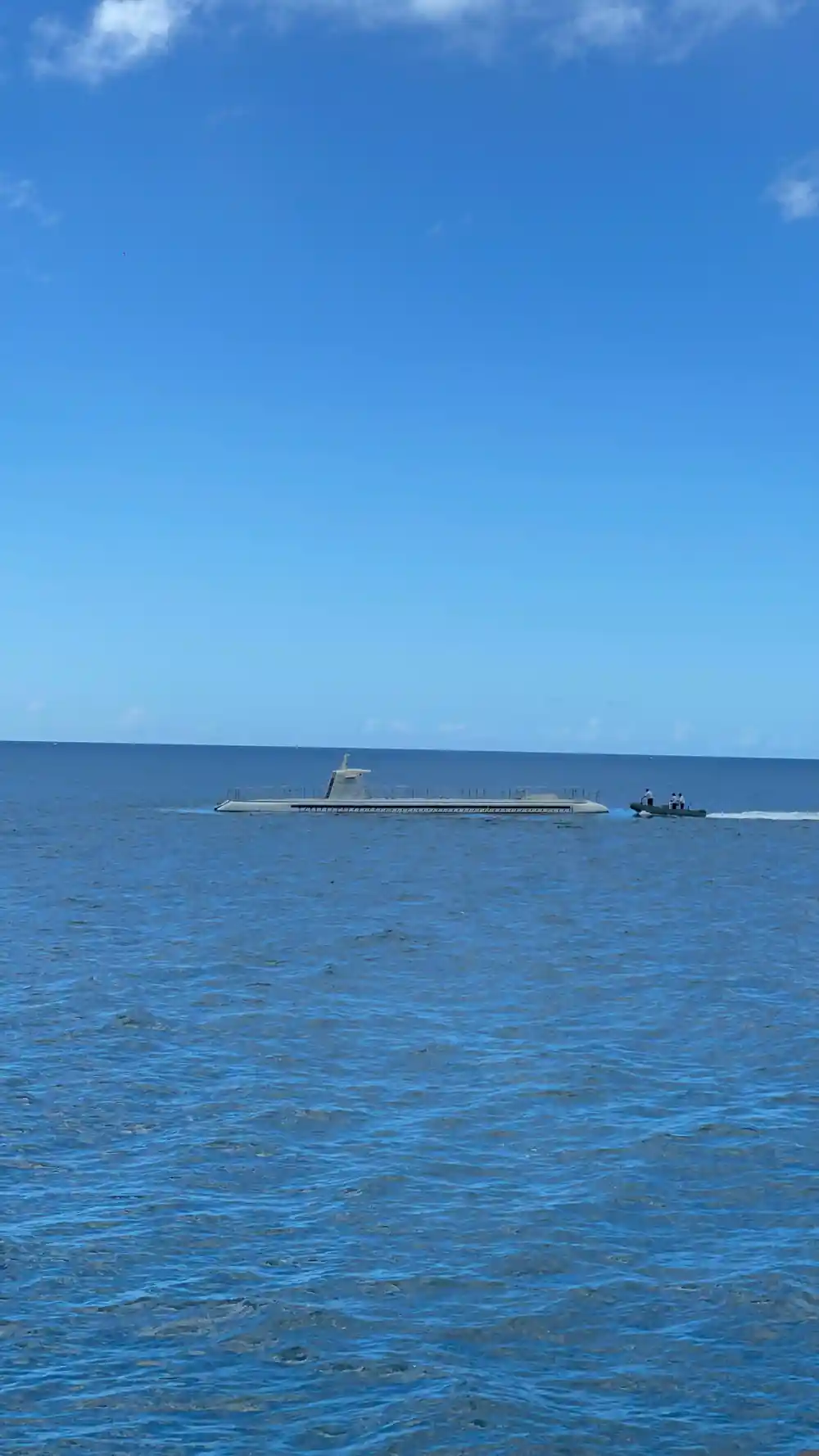 The submarine on the surface with the transfer boat alongside